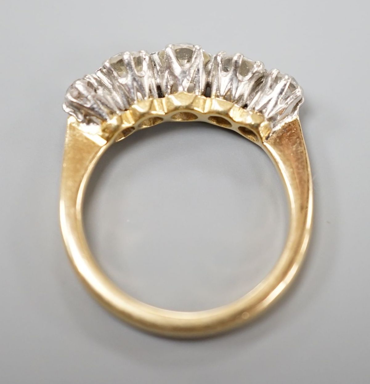 An 18ct and graduated five stone diamond set half hoop ring, size K, gross weight 4 grams.